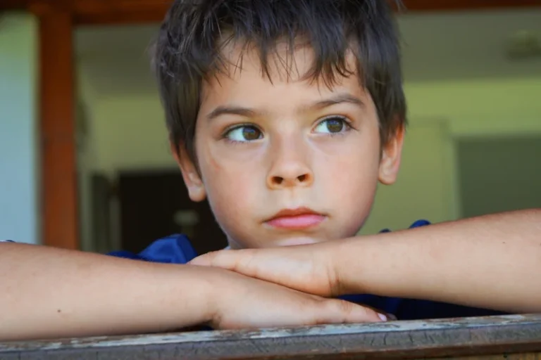 Dečak sa zamišljenim izrazom lica koji gleda unazad, simbolizujući emocije nade i nesigurnosti