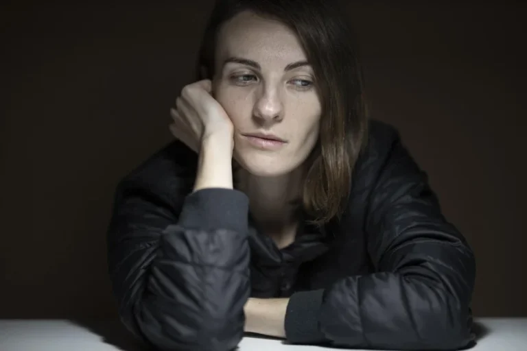 Zamislena mlada žena sa tužnim izrazom lica, gledajući u daljinu dok razmišlja